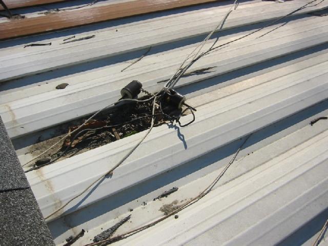 Electrical service wires laying on metal roof- Shock hazard